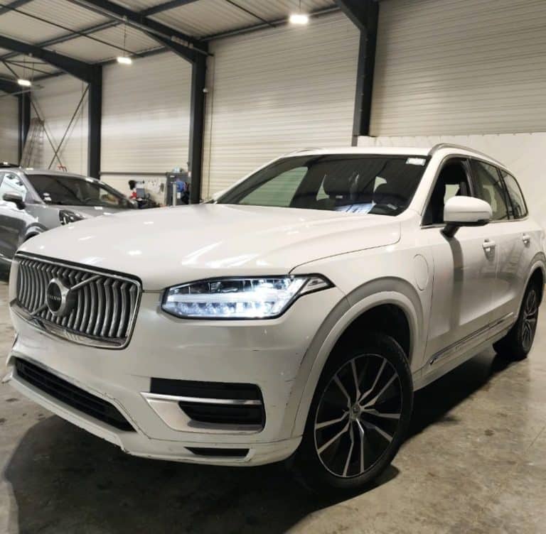 Volvo XC90 T8 blanc de 2021 vu de trois quarts avant, feux à LED allumés